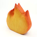 Whittled wooden sculpture of a flickering flame, with cute cartoon eyes and an open mouth smile. Painted like Calcifer from Howl's Moving Castle.