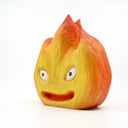 Whittled wooden sculpture of a flickering flame, with cute cartoon eyes and an open mouth smile. Painted like Calcifer from Howl's Moving Castle.