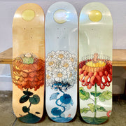 3 skateboard decks with floral themed illustrations.