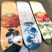 3 skateboard decks with floral themed illustrations.