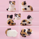 Many view of a needle felted calico cat, sitting as a "loaf"