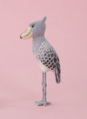 Needle felted sculpture of a shoebill bird, gray, white and dark gray with a yellow beak.