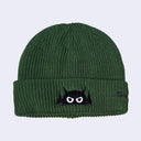 Green beanie with a black and white logo on a light gray background