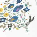 Close up detailing of a card with an illustration of a tiny man holding a giant flower bouquet.