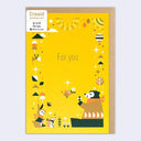 Yellow greeting card with a graphic of a bear sitting on the ground holding out a flower to a flying by bird. Border around are various nature themes and more animals.