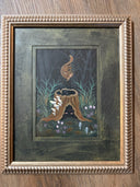 Framed artwork of a tree trunk, with an illuminated pair of eyes within it. Mushrooms grow on the side of it and a chipmunk levitates out from the trunk, upside down.