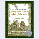 Fiftieth Anniversary commemorative edition of the children's book 'Frog and Toad Are Friends' by Arnold Lobel, featuring a green ornate border, illustrated frogs sitting among foliage, and a silver Medallion of the Medal for Excellent Children's Literature on the lower right.