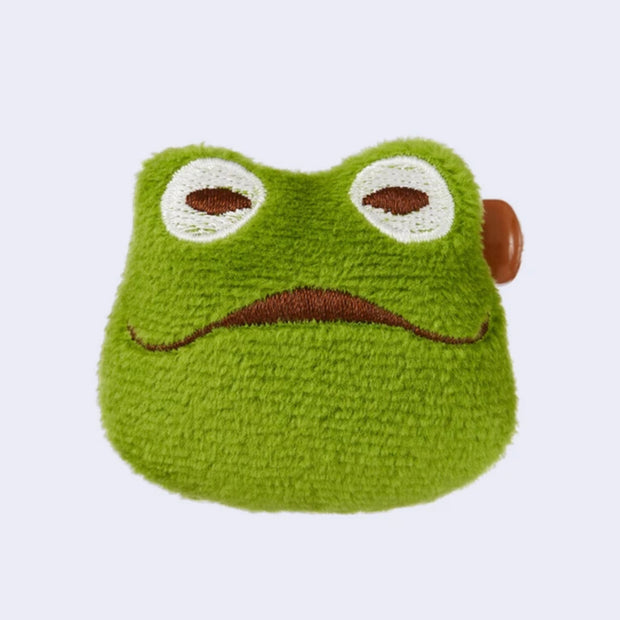 Green frog-shaped plush toy with a sad expression on a white background