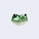 3D ceramic brooch/pin of a frog's head - green in coloring with 2 large eyes and a closed mouth.