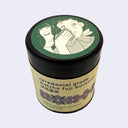 Ceremonial grade matcha tea canister with decorative lid on a light gray background