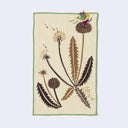 Rectangular cream colored towel with a green border, of a dandelion flower and pointed leaves. A small green yokai stands on top of the dandelion, with a bag of winds.