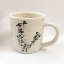White mug with decorative design on a white background