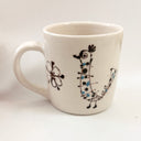 White mug with black and blue decorative elements on a white background