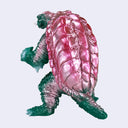 A toy monster figure of Gamera with a green body, pink shell, and yellow eyes, shown against a plain light gray background.