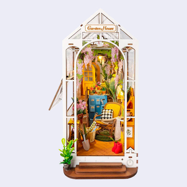 Fully assembled book nook diorama of a greenhouse setting, doubling as a garden and a craft room.