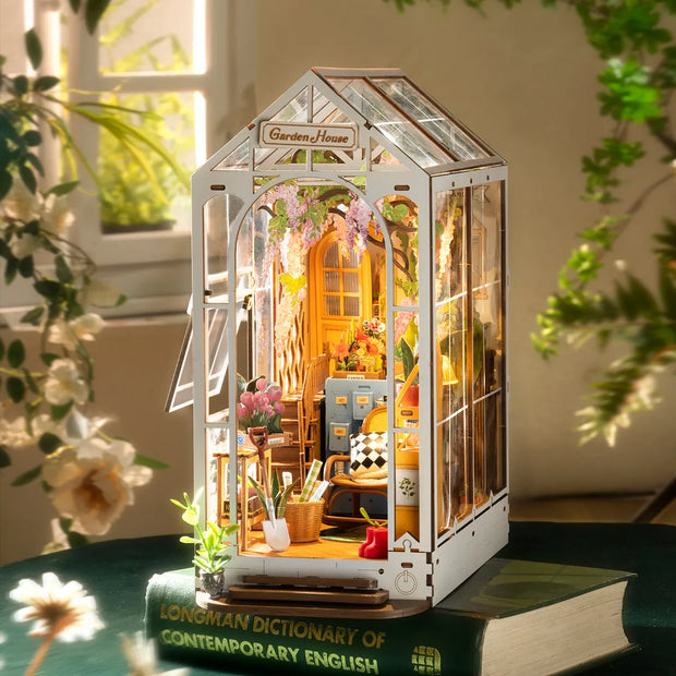 Fully assembled book nook diorama of a greenhouse setting, doubling as a garden and a craft room.