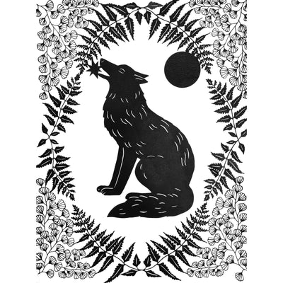 Black paper cutting art. A wolf sits and holds a star in its mouth, it is framed by delicately cut fern leaves and flowers and a full moon.