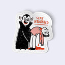 Sticker with a cartoon character vampire, holding a passed out person with blood trickling from their neck. Text says 'Stay Hydrated'