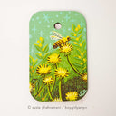 Painting on rounded corner wood panel of a bumble bee on top of a yellow dandelion. Background is mint green with more grass and yellow flowers.