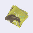 Folded green handkerchief with a brown goat design on a light gray background