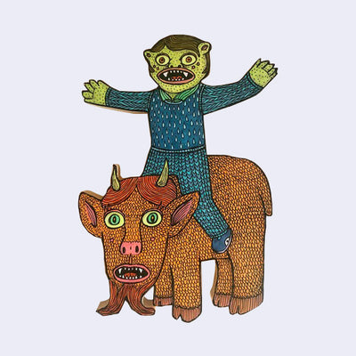 Die cut wooden sculpture of a green goblin kid sitting excitedly atop a brown goat with a very large face. 