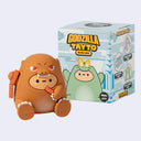 Toy figures in front of a 'Godzilla Tayto' blind box packaging on a light gray background.