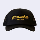 Black colored hat with "giant robot" written along the front in yellow cursive, and "since 1994" written below in plain capital font.