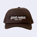 Warm brown colored hat with "giant robot" written along the front in white cursive, and "since 1994" written below in plain capital font.