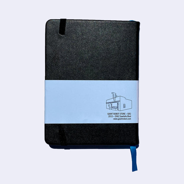 Backside of a black pleather covered journal with an elastic closure and a shiny blue page marking ribbon.