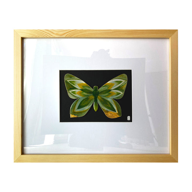 Illustration on cut out paper of a butterfly with gold and deep green wings, with abstract wing patterns akin to pointed leaves. Butterfly is mounted on black paper and in a light grain wooden frame with a white mat.
