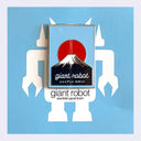 A rectangular enamel pin featuring a red sun over a black-and-white mountain with the words 'giant Robot' and Japanese text, displayed on a light blue background with white robot silhouettes and the text 'giant robot sawtelle japantown'.