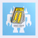 A novelty enamel pin shaped like a slice of tamago sando (Japanese egg sandwich) with the text 'TAMAGO SANDO Giant Robot' on a yellow header, displayed on a blue card with a white robot silhouette.