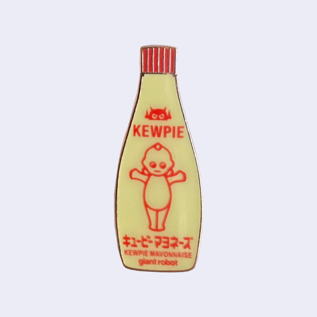 Die cut enamel pin of a bottle of Kewpie brand mayonnaise, with an added "giant robot" written small along the bottom.