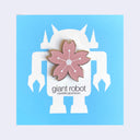 Die cut enamel pin of a stylized cherry blossom, with slightly pointed geometric petals and a white line art center. Pin is on light blue background.