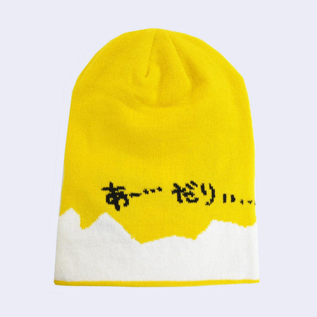Back view of a yellow beanie with a jagged white bottom border, with Japanese kanji written.