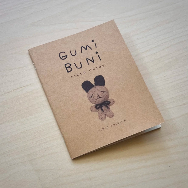 Zine booklet with a tan cover and an image of a crocheted bunny character. Text reads "Gumi Buni Field Guide"