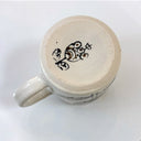 Ceramic mug with decorative handle on a white background