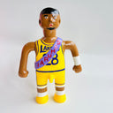 Toy figure of a basketball player in a yellow jersey with a sash on a white background