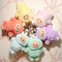 Set of colorful Yeti character plush keychains on a textured surface