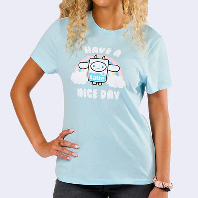 Light blue t-shirt with a graphic of Sanrio's Cinnamoroll, dressed as a carton of milk and standing in front of a pastel rainbow with text that reads "Have a Nice Day"