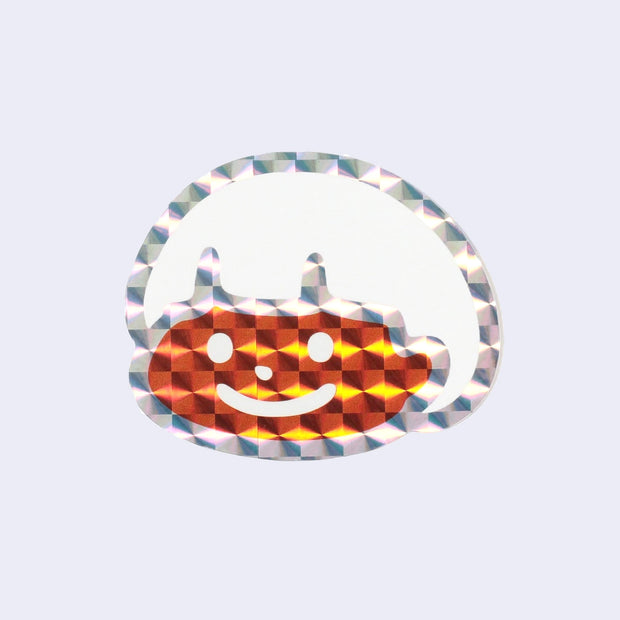 Holographic sticker of a cartoon character with an orange face and white bowl cut hair.