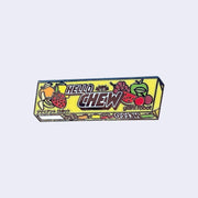 Die cut enamel pin of a sleeve of Hi-Chew candy in yellow product packaging, with the design slightly edited. The front says "Hello Chew" and has a small graphic of a robot head, along with "giant robot" written in lowercase in bottom right corner.