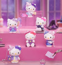 Set of Hello Kitty figurines on a pink surface with a blurred background