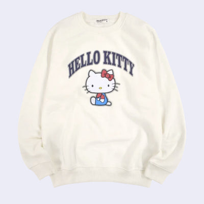 Off white pull over sweater with a graphic of Hello Kitty, sitting and looking at the viewer. Above, written in outlined capitalized letters says "Hello Kitty."