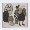 Beige/gray square handkerchief featuring an illustration of a heron, standing with a blue fish in its mouth. It stands next to stylized brown and gray rocks.