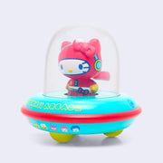 Vinyl figure of Hello Kitty, dressed in a red space suit. She sits inside of a UFO with a donut shaped body that is teal and reads "Kawaii Arcade." On the UFO body are 8 bit style drawings of Sanrio Characters.