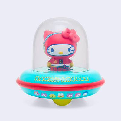 Vinyl figure of Hello Kitty, dressed in a red space suit. She sits inside of a UFO with a donut shaped body that is teal and reads "Kawaii Arcade." On the UFO body are 8 bit style drawings of Sanrio Characters.
