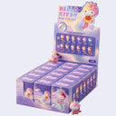 A retail display box of Hello Kitty Unicorn Costume blind boxes, featuring purple packaging with character illustrations and small Hello Kitty figures placed on and in front of the display.