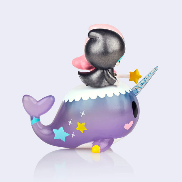  Vinyl figure of Sanrio's Little Twin Stars, a pink haired girl and a blue haired boy, riding atop of a smiling purple narwhal. Side view. 