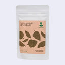Tea package with leaf design and text on a light gray background